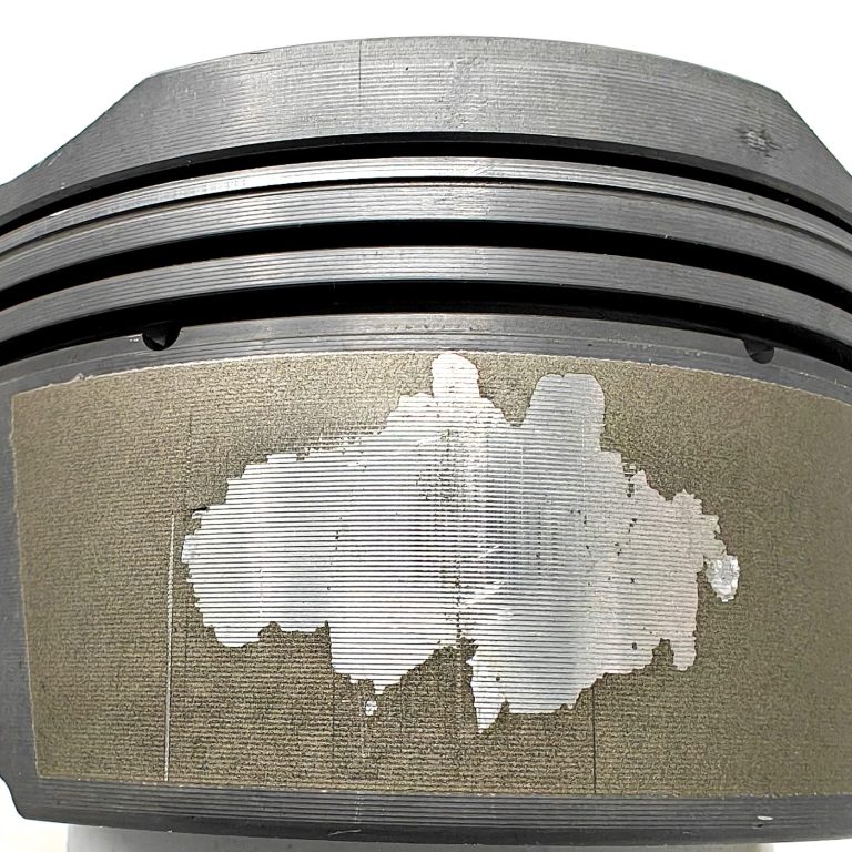 Beschädigte MAHLE Kolbenhemdbeschichtung eines Porsche 997 Kolben